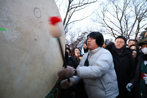 청년의 대북타고 모습. 청년이 북채를 들고 새해 희망의 소리를 전하고 있다
