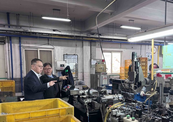 우리은행 정진완 은행장(왼쪽)이 국내 중소기업을 방문해 생산 현장에 대해 관계자로부터 설명을 듣고 있다