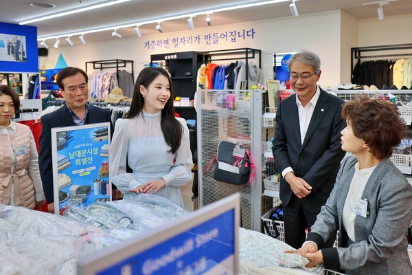 우리금융그룹 창립 25주년을 맞아 굿윌스토어 밀알우리금융점에서 임종룡 우리금융그룹 회장(왼쪽)과 그룹 모델 아이유(오른쪽)가 '남대문시장 특별전'을 기념해 사진을 촬영하고 있다(사진 = 우리금융그룹)